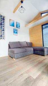 salon z fioletową kanapą w pokoju w obiekcie Przytulny domek 150 m od jeziora w Charzykowach