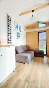 ein Wohnzimmer mit einem Sofa in einem Zimmer in der Unterkunft Przytulny domek 150 m od jeziora in Charzykowy