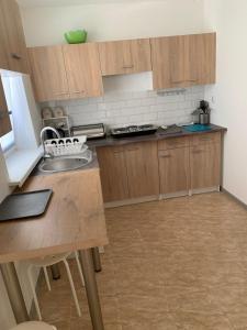 a kitchen with wooden cabinets and a sink at Cichy zakątek in Zbiczno +4 photos