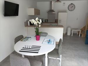 un tavolo bianco e sedie con un vaso di fiori sopra di Le P'tit Courtil - Maison à la campagne a Plédran Altre 7 foto