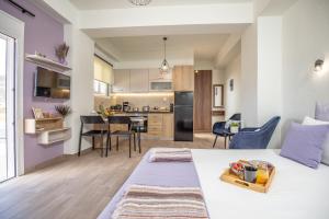 ein Schlafzimmer und ein Wohnzimmer mit einem Bett und einer Küche in der Unterkunft Studio Athena with panoramic view of MakryGialos in Pilalímata