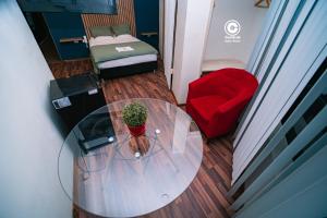 un tavolo di vetro con una pianta in vaso e una sedia rossa di Tarapoto central suites a Tarapoto