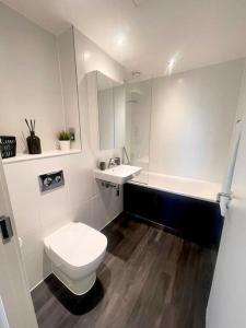 a white bathroom with a toilet and a sink at Opulent 3 -Bedroom Penthouse with Stunning Views in Newcastle upon Tyne