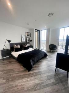 a bedroom with a large bed in a room with windows at Opulent 3 -Bedroom Penthouse with Stunning Views in Newcastle upon Tyne