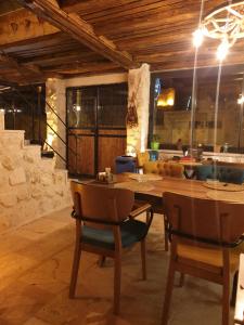 ein Esszimmer mit einem Holztisch und Stühlen in der Unterkunft Ceran Stone House in Nevşehir