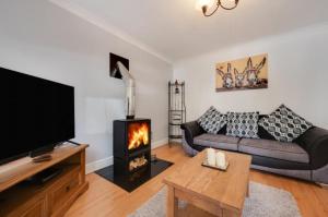 a living room with a couch and a fireplace at 3 Bed Holiday Home in Llandeilo with log burner in Llandeilo