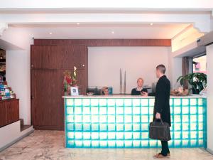 فندق Esprit d'Azur في نيس: رجل واقف امام بار