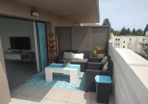- un salon avec un canapé et une table sur un balcon dans l'établissement Magnifique rooftop duplex climatisé aux ARCEAUX, à Montpellier