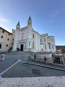 a large white building with two towers on a street at PALAZZO SASSATELLI - Nel cuore di Cascia in Cascia