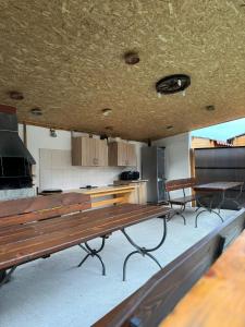 una cocina con un banco de madera y una mesa en Cabanutele La Denisa, en Dubova
