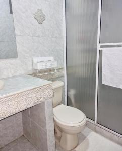 Un baño blanco con inodoro y ducha. en Habitación amplia y cómoda con baño privado, en Bucaramanga