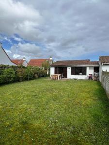 a yard with a house and a table in it at Boho Beach House De Haan in De Haan