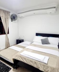 Duas camas num quarto com paredes brancas em Habitación amplia y cómoda con baño privado em Bucaramanga