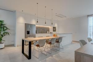 a kitchen with a large wooden table and white chairs at Green House - Modern Villa in Tenerife, Spain in Guía de Isora