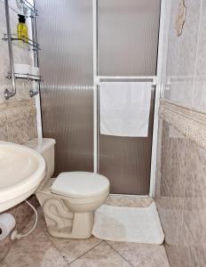 uma casa de banho com um chuveiro, um WC e um lavatório. em Habitación amplia y cómoda con baño privado em Bucaramanga