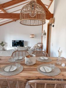 a dining room with a wooden table with rattan chairs at Boho Beach House De Haan in De Haan