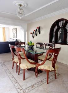 uma sala de jantar com uma mesa de vidro e cadeiras em Habitación amplia y cómoda con baño privado em Bucaramanga