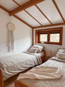 two beds in a room with two windows at Boho Beach House De Haan in De Haan