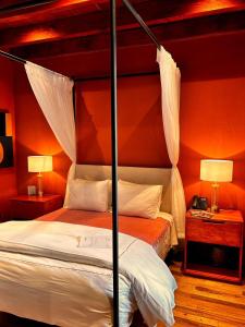 een slaapkamer met een hemelbed en 2 lampen bij Bito's Hotel Boutique in San Miguel de Allende