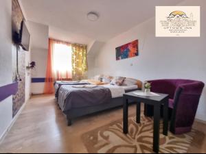 1 dormitorio con cama, mesa y sofá en Uptown Inn, en Sarajevo