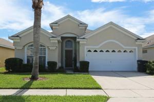 a house with a palm tree in front of it at Luxury 4BD Single-Level Villa with Private Pool - Windsor Palms - Sleeps 8 in Kissimmee