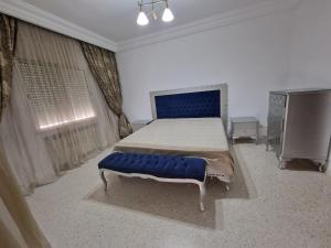 a bedroom with a large bed with a blue bench at Dar Salem III in Tunis
