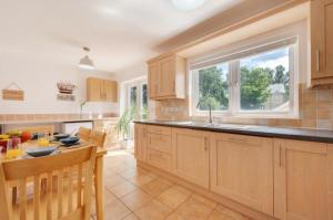a kitchen with wooden cabinets and a table and a window at 3 Bed Holiday Home in Llandeilo with log burner in Llandeilo