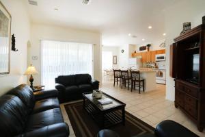 un soggiorno con divano e tavolo di Luxury 4bd Villa at Windsor Palms Resort. a Kissimmee