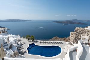 een uitzicht op de oceaan vanuit een resort met een zwembad bij Volcano View by Caldera Collection in Fira