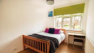 a small bedroom with a bed and a window at Belgrave Gardens in East Barnet