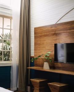 a room with a tv on a wooden wall at Hotel Aranjuez in San José +37 photos