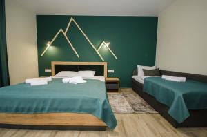 een slaapkamer met 2 bedden en een groene muur bij Family Residence in Boekovel
