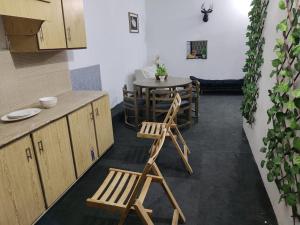 una cucina con 2 sedie in legno e un tavolo di Syedah 's Homestay a Lahore