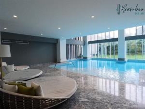 a large swimming pool with chairs in a building at Luxury Condo Paradox Santa Fe By Bamboo Skylife in Mexico City