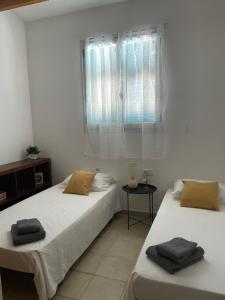 Duas camas num quarto com uma janela em Las Margaritas Binibeca Menorca em Binibeca
