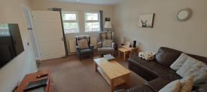 a living room with a couch and a table at Ben Reoch Cottage - Loch Lomond and Arrochar Alps in Tarbet