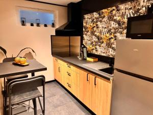 a kitchen with a refrigerator and a table in it at Les bulles d'or in Flémalle-Grande