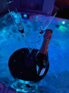 una botella de vino sentada en un vaso en Les bulles d'or en Flémalle-Grande
