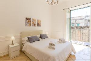 1 dormitorio con cama blanca y ventana grande en Montesanto Family, en Nápoles