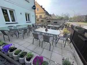 a patio with tables and chairs and potted plants at Penzion Star Doksy in Doksy