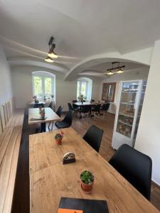 a dining room with a large wooden table and chairs at Penzion Star Doksy in Doksy