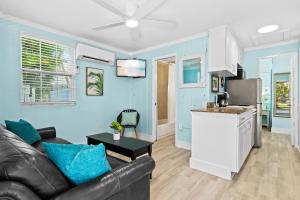 een woonkamer met een bank en een keuken bij Parrot Beach Cottages Suite #2 in Siesta Key