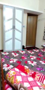 een slaapkamer met een bed met bloemen erop bij ZAIN HOME 1 - 2BHK@ Sulthanpalya Hebbal in Bangalore