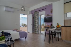 Schlafzimmer mit einem Bett und einem Tisch mit einem Laptop in der Unterkunft Studio Athena with panoramic view of MakryGialos in Pilalímata