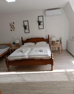 Schlafzimmer mit einem Holzbett mit weißer Bettwäsche in der Unterkunft Sunčana Kuća in Krupanj