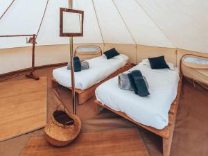 ブイヨンにあるLodg'ing Nature Camp Ardennes NEW 2024のテント内のベッド2台が備わる部屋