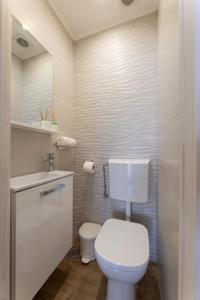 Baño blanco con aseo y lavamanos en Apartment Tinel, en Trogir