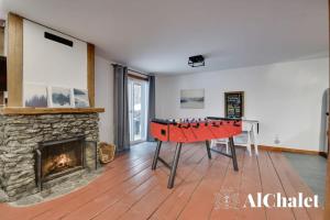 ein Wohnzimmer mit einer Tischtennisplatte vor dem Kamin in der Unterkunft Lakaban - familial & paisible in Saint-Raymond