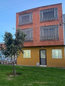 a building with a tree in front of it at Santamaria Lago Home in Bogotá