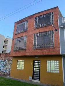um edifício de tijolos com janelas e graffiti em Santamaria Lago Home em Bogotá